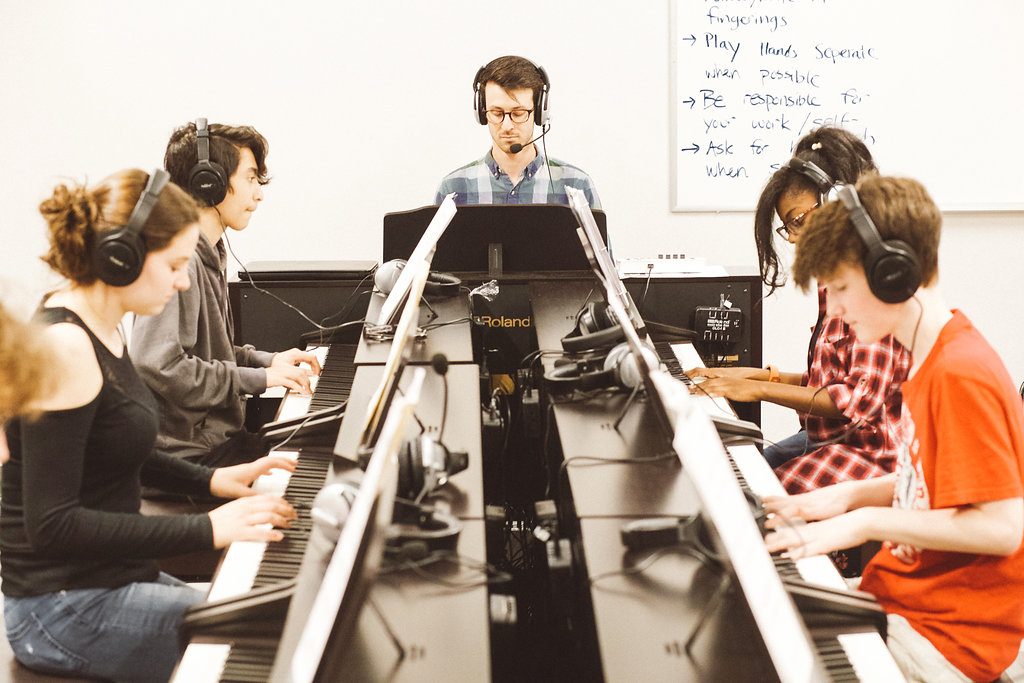 students playing keyboards in class